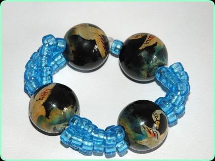 Large chunky bracelet with large wooden beads painted with swans and with blue plastic beads on elastic